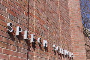 Photo of a brick building with a sign that says "speech sciences"