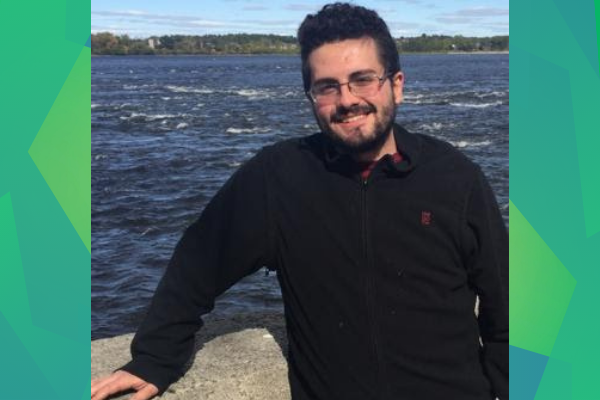 Smiling man outdoors in front of lake